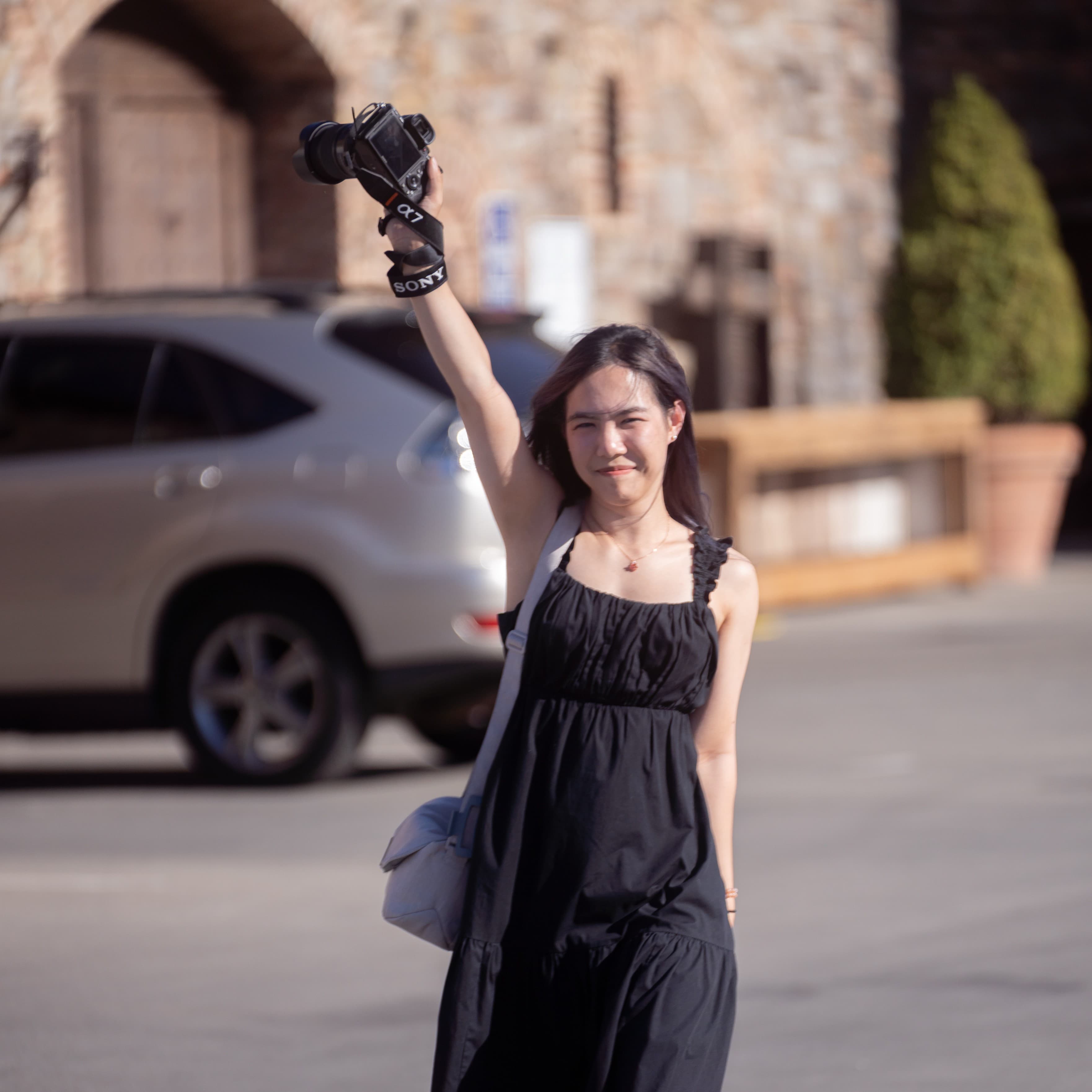 Susana holding a camera overhead, mid-shoot